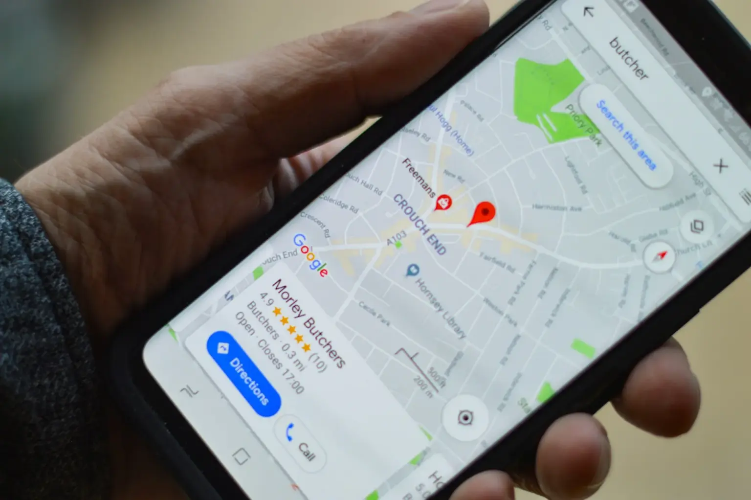 Hand hält Smartphone mit Google-Maps-Karte